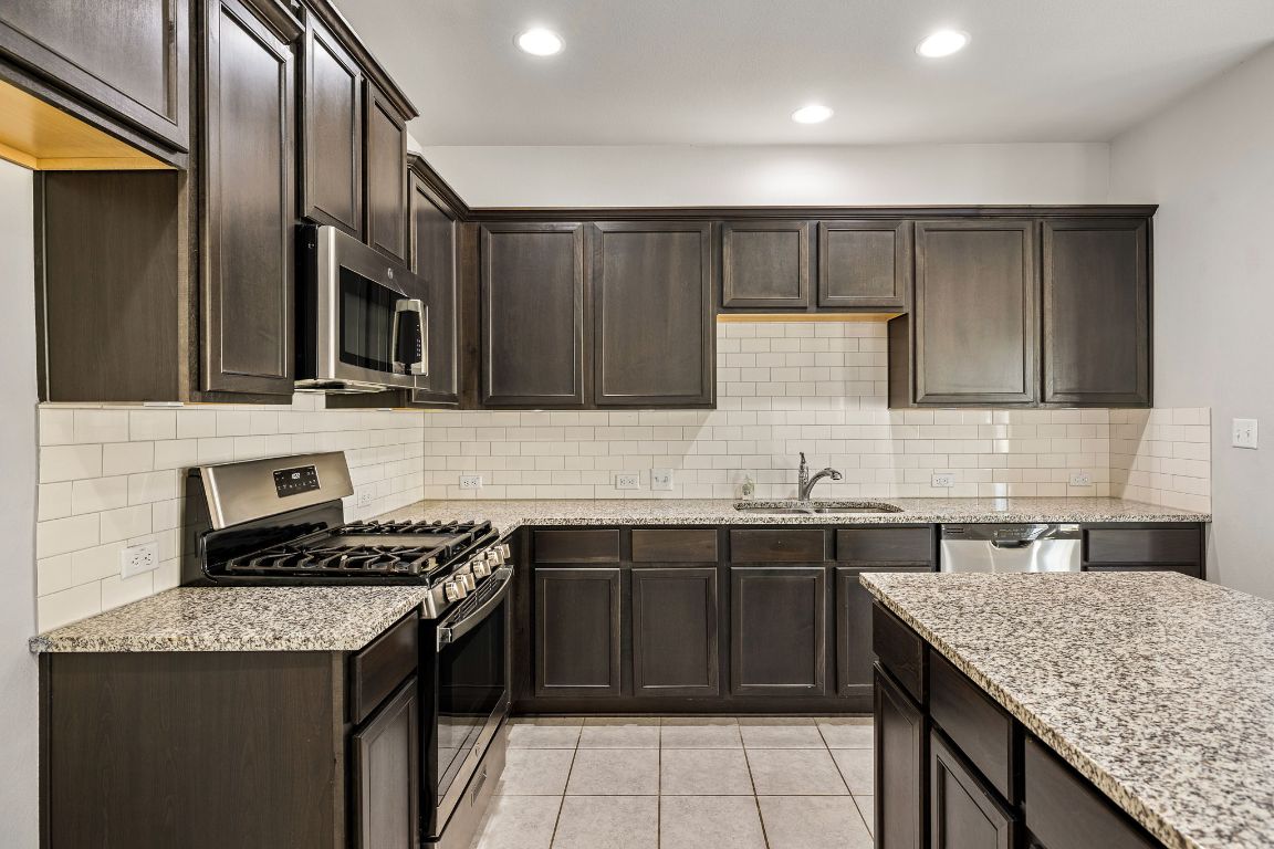 321 Arabian Colt Drive Georgetown, TX 78626 - Photo 10 of 24 a kitchen with a sink stove and cabinets
