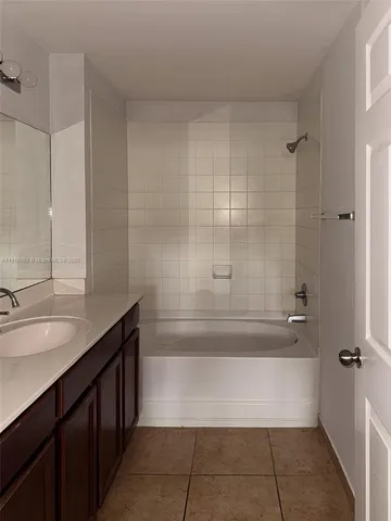 a bathroom with a granite countertop sink a toilet and bathtub