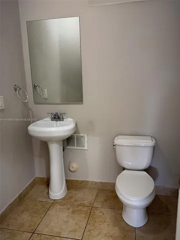 a bathroom with a sink toilet and a mirror