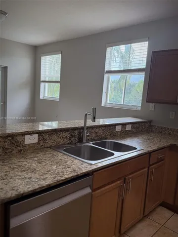 a kitchen with sink a window and cabinets
