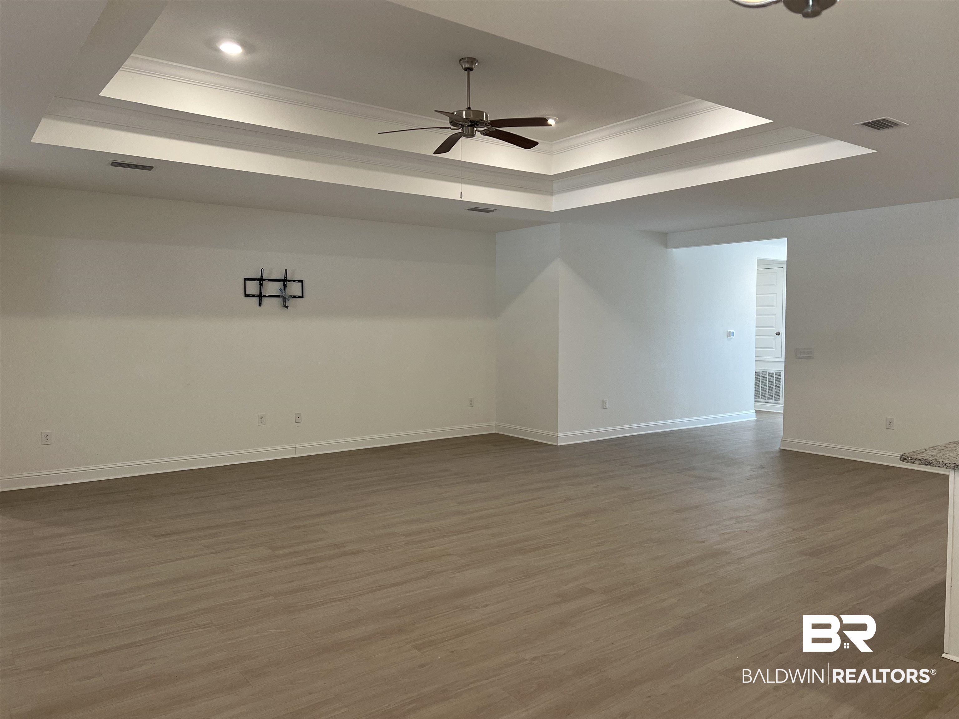 8855 Calverton Street Foley, AL 36535 - Photo 37 of 76 Spare room featuring ceiling fan, ornamental molding, and a tray ceiling