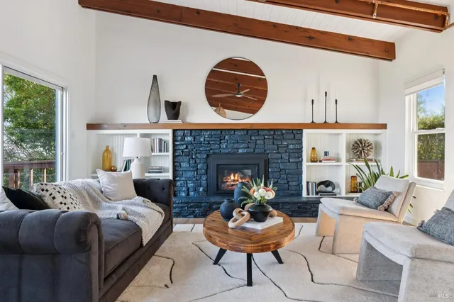 a living room with furniture a fireplace and a large window