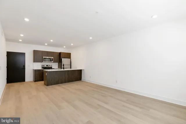 a view of kitchen with kitchen island microwave and refrigerator