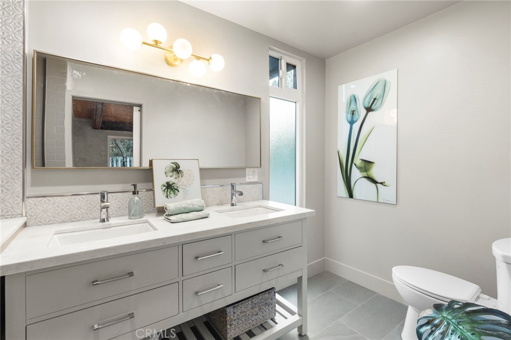 4084 Miramonte Place Riverside, CA 92501 - Photo 40 of 60 a bathroom with a double vanity sink and a mirror