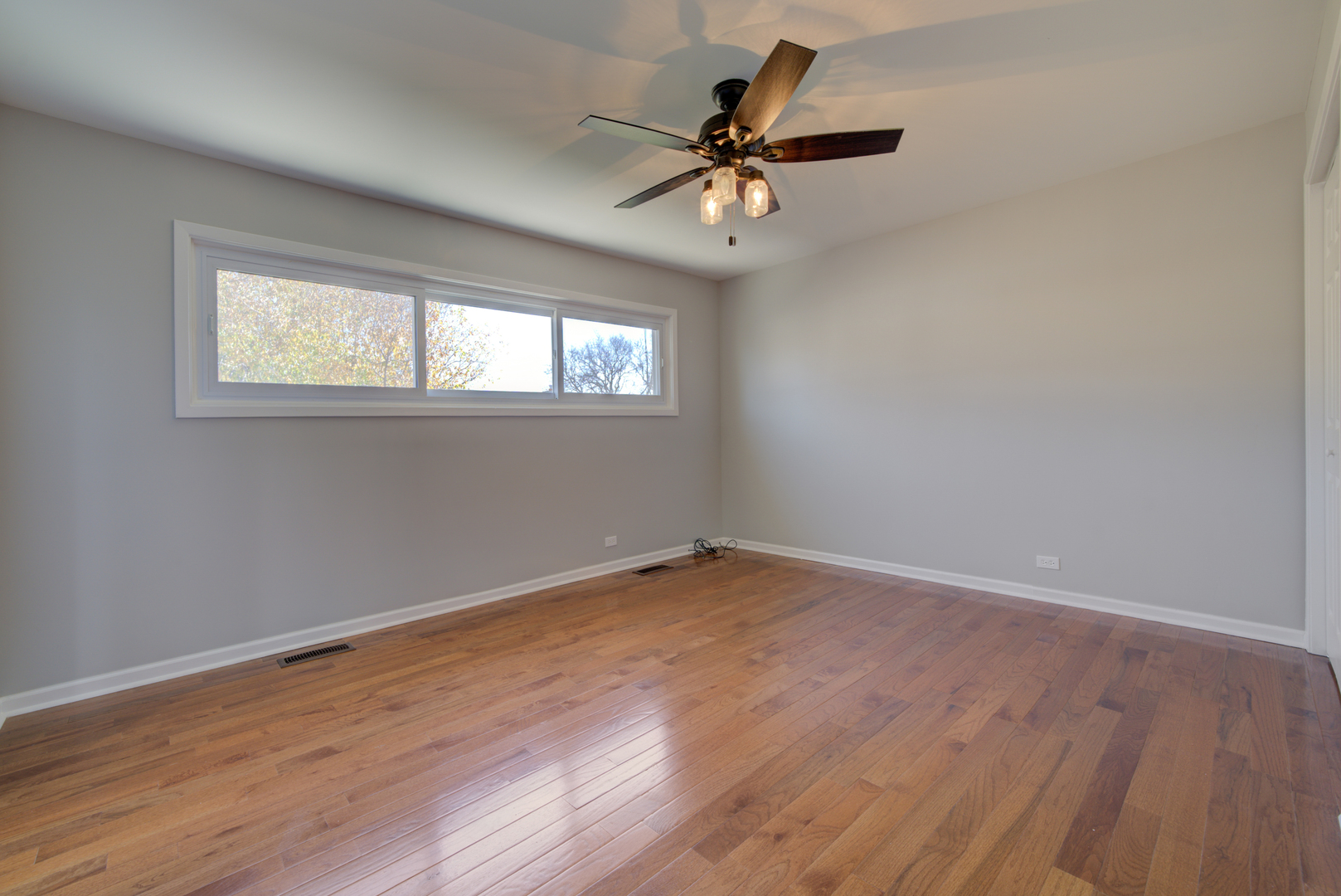 9211 Washington Road Morton Grove, IL 60053 - Photo 15 of 29 an empty room with wooden floor fan and windows