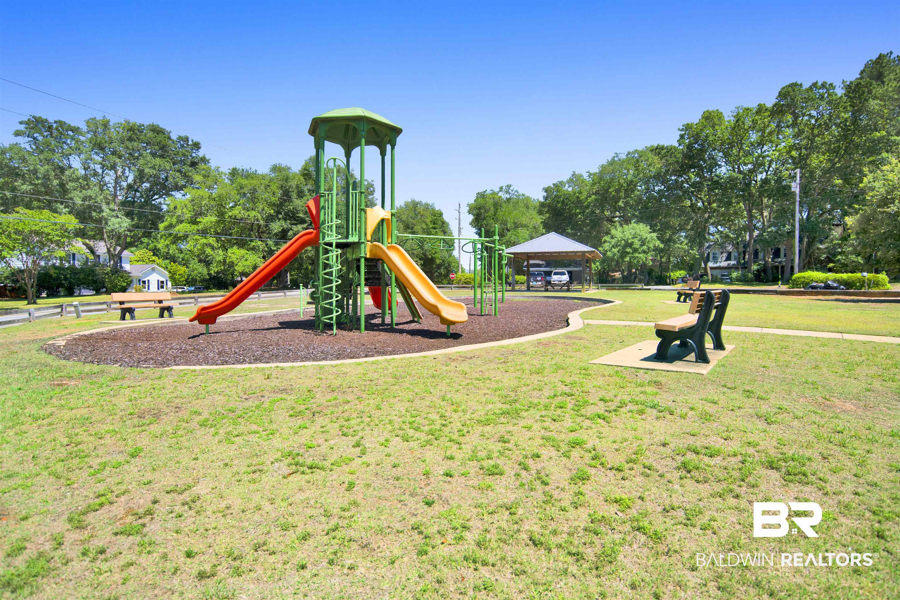 107 Virginia Circle Daphne, AL 36526 - Photo 42 of 47 Community park featuring a multi-color playground structure with slides, surrounded by a wood chip surface