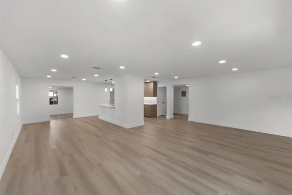 a view of an empty room with wooden floor