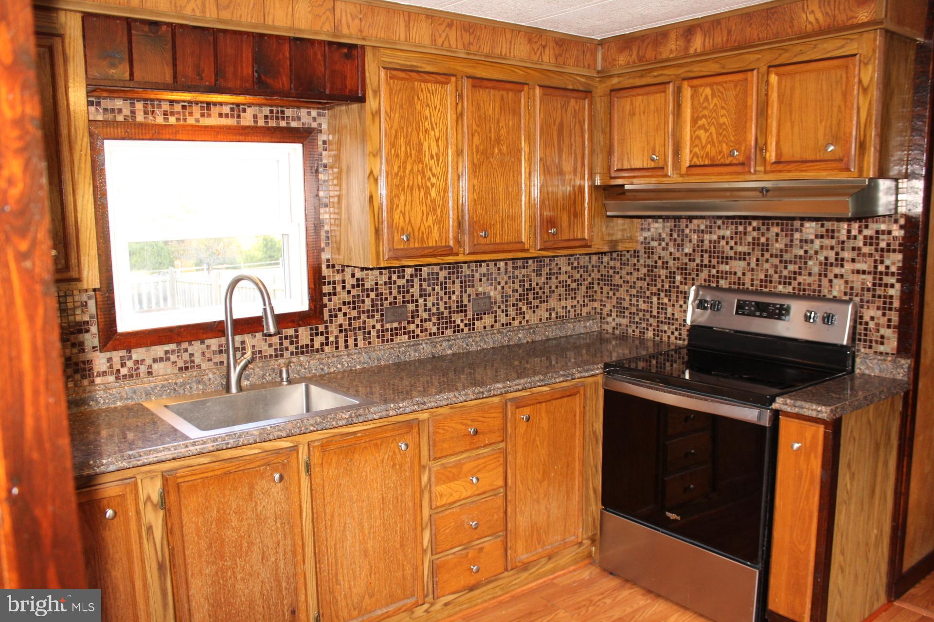 5274 Burr Hill Road Rhoadesville, VA 22542 - Photo 31 of 66 a kitchen with granite countertop a sink and a stove