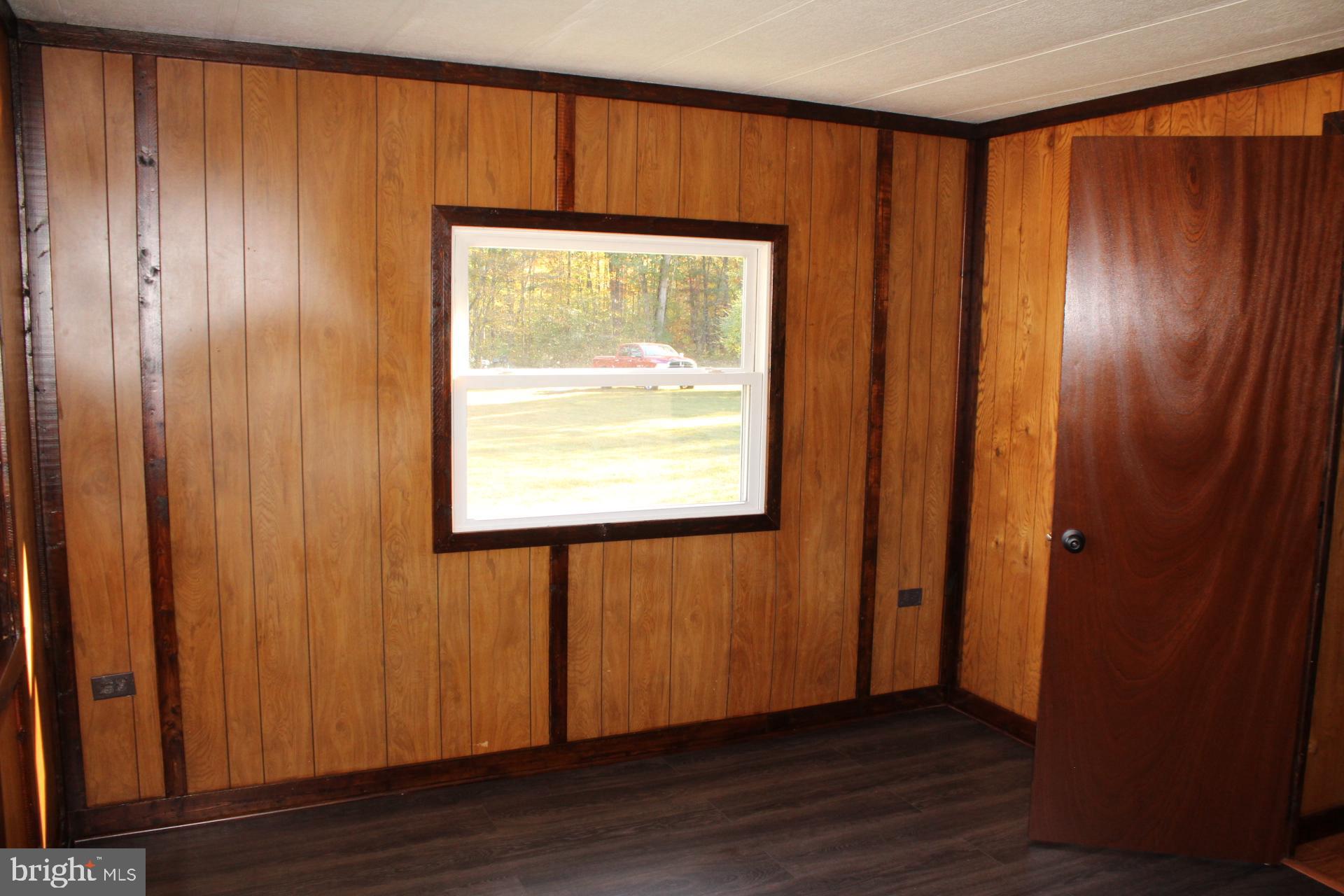 5274 Burr Hill Road Rhoadesville, VA 22542 - Photo 40 of 66 an empty room with wooden floor and windows with curtains