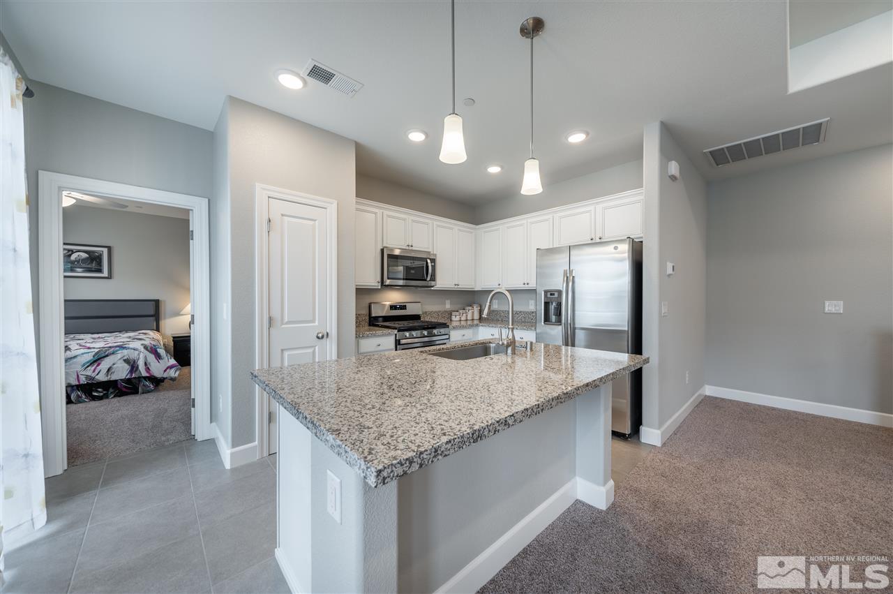 1852 Sea Horse Road, Unit A Reno, NV 89521 - Photo 7 of 21 a large kitchen with kitchen island a large counter top and refrigerator