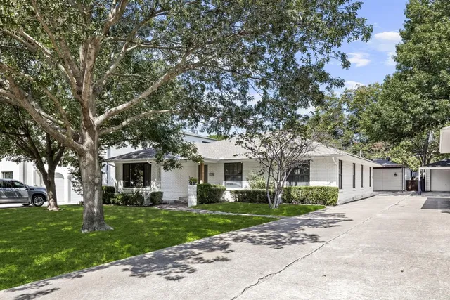a view of a house with a large tree