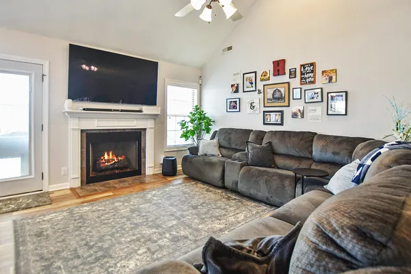 a living room with furniture a flat screen tv and a fireplace