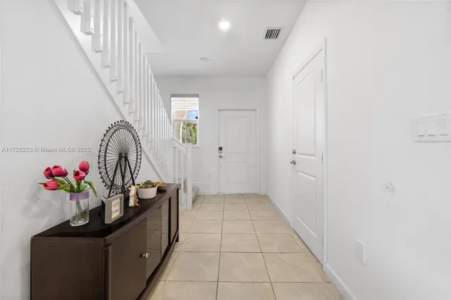 a view of a hallway to a livingroom with entryway