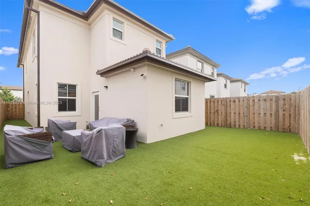a backyard of a house with table and chairs