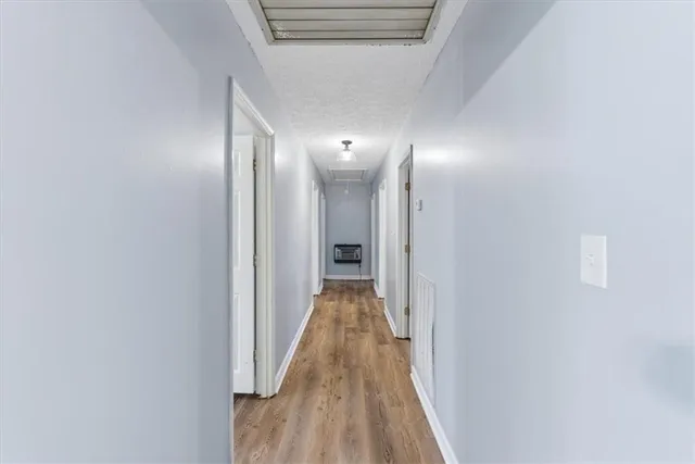 a view of an empty room with a window and wooden floor