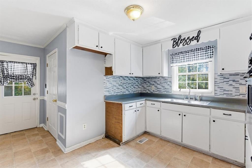 1500 Moores Ferry Road Southwest Plainville, GA 30733 - Photo 7 of 31 a kitchen with granite countertop a sink and white cabinets
