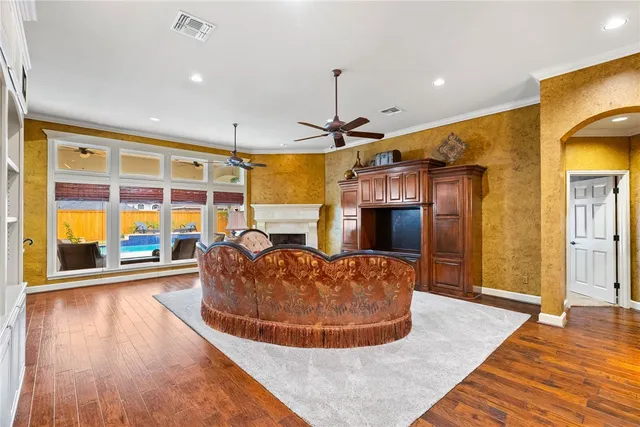a living room with stainless steel appliances kitchen island granite countertop a couch and wooden floor