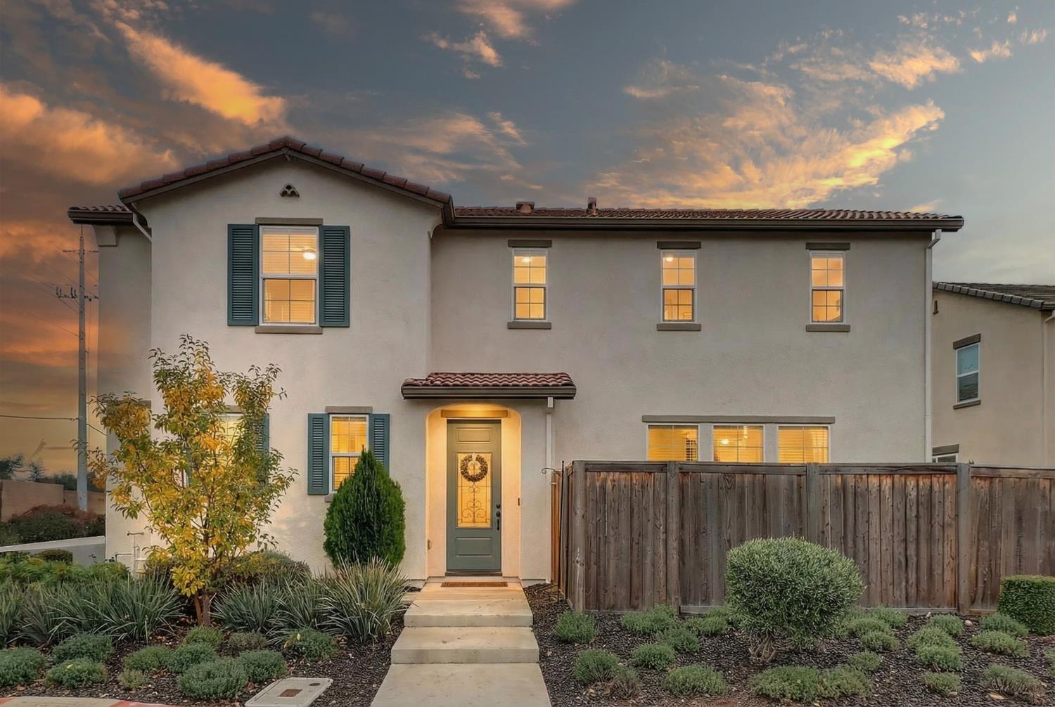 a front view of a house with plants
