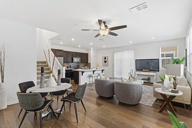 a living room with furniture kitchen view and a flat screen tv