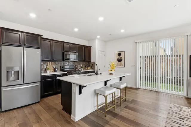 a kitchen with stainless steel appliances sink stove microwave and cabinets