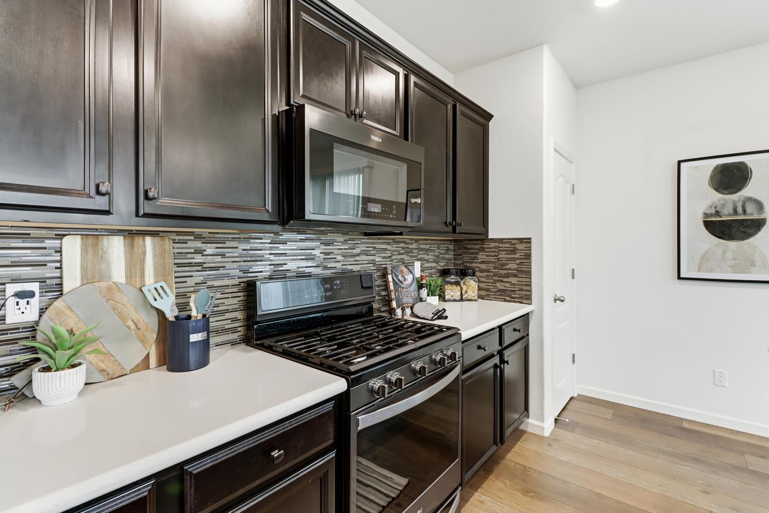 8900 Sheldon Terrace Lane Elk Grove, CA 95758 - Photo 20 of 57 a kitchen with stainless steel appliances a stove a sink cabinets and a wooden floor