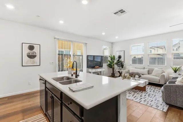 a living room with furniture a dining table and a chandelier