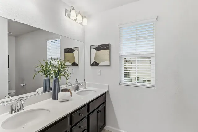 a view of a big room with windows and chandelier fan