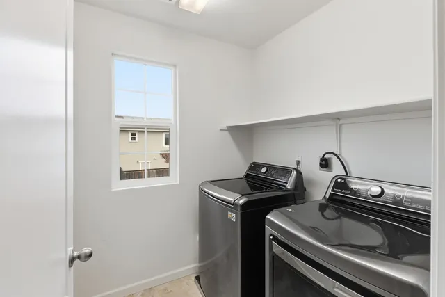 a view of a house with wooden fence and potted plants