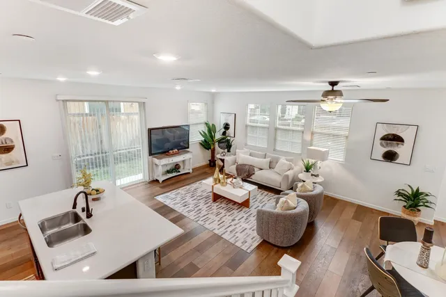 a living room with furniture flat screen tv and a large window