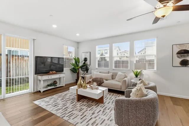 a living room with furniture potted plant and a large window