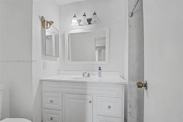 a bathroom with a sink vanity and a mirror
