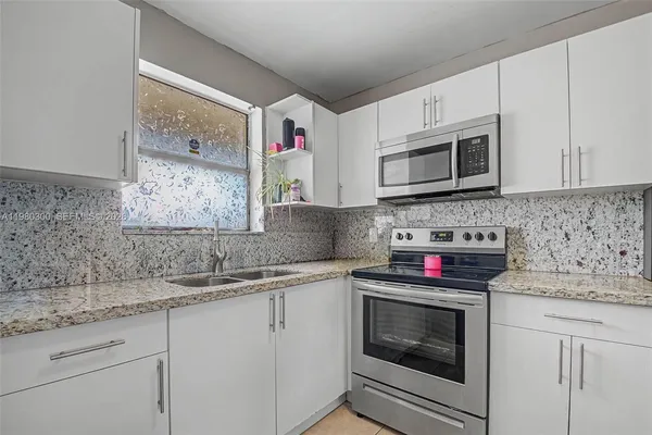 a kitchen with granite countertop cabinets stainless steel appliances and a sink