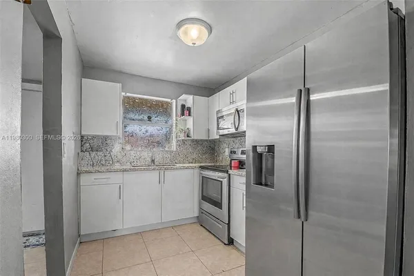 a kitchen with stainless steel appliances granite countertop a refrigerator and a sink