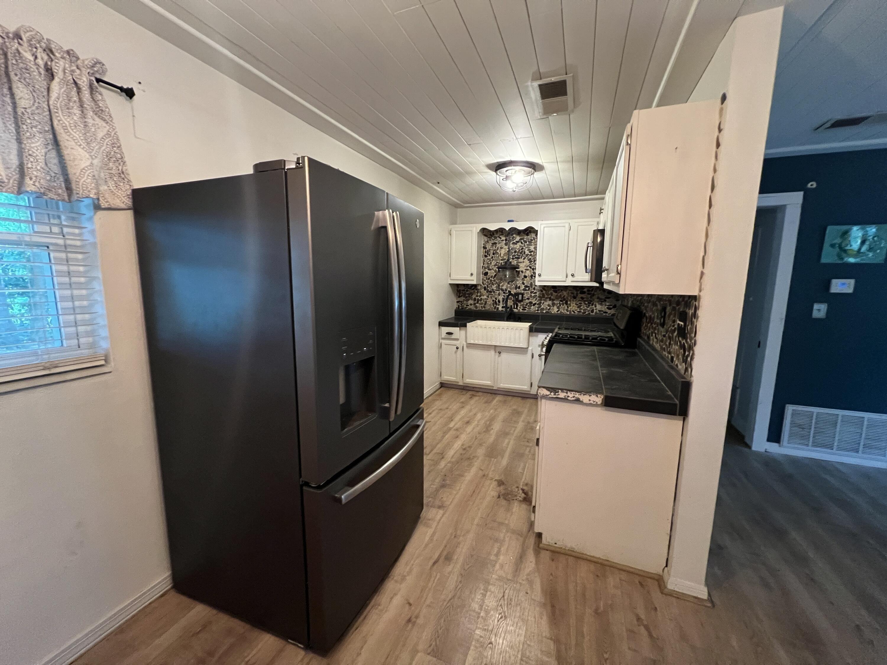 123 Panama Drive Crestview, FL 32536 - Photo 2 of 10 a kitchen with a refrigerator stove and wooden floor