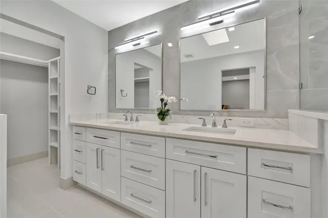 a bathroom with double sink and a mirror