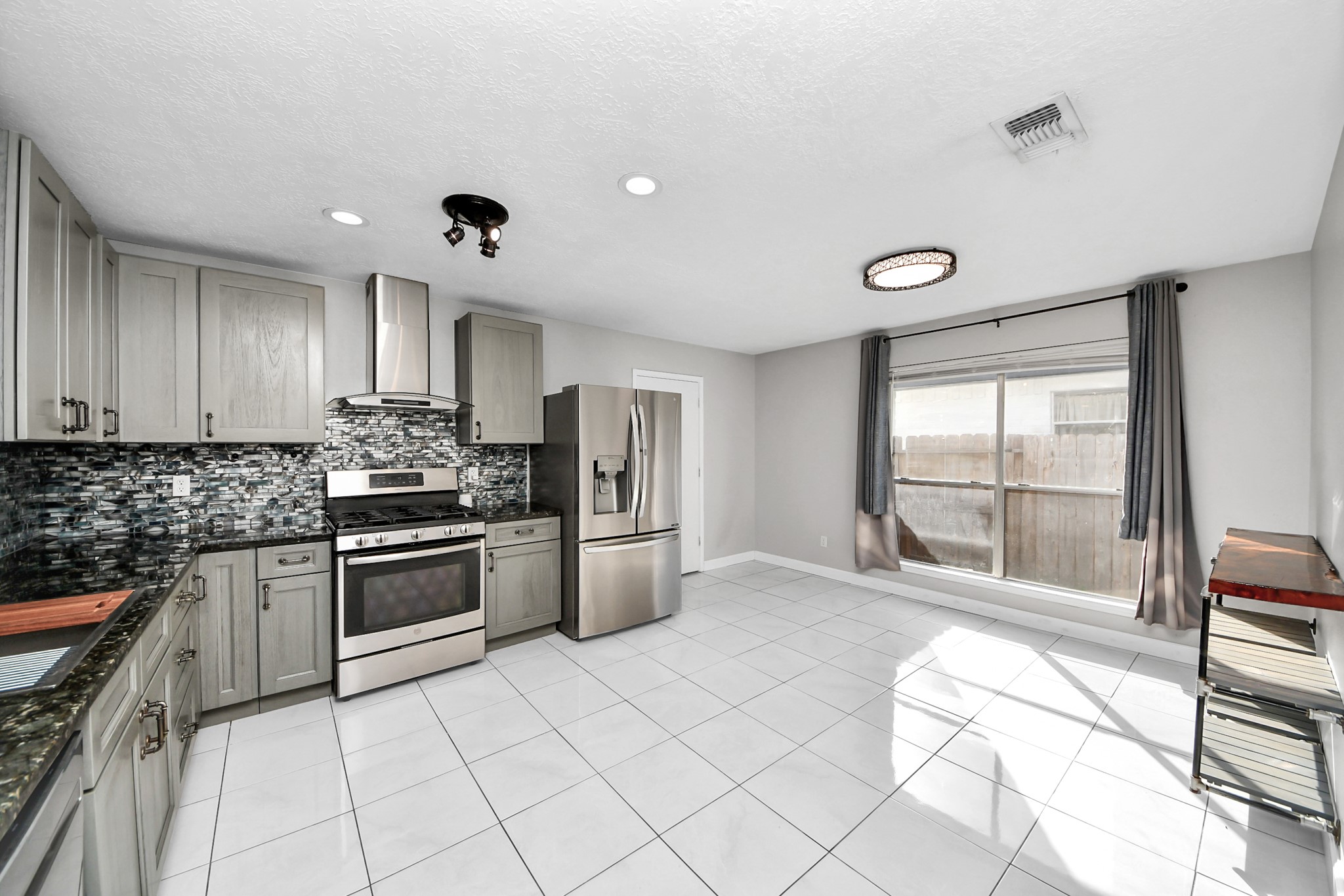 28707 Stapleford Street Spring, TX 77386 - Photo 10 of 38 a kitchen with stainless steel appliances granite countertop a stove top oven a sink and a refrigerator