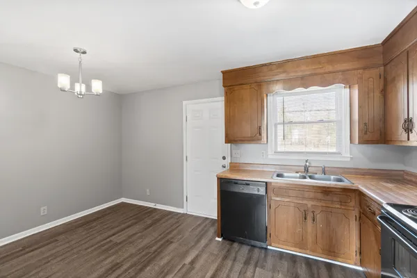 a kitchen with a sink cabinets and wooden floor