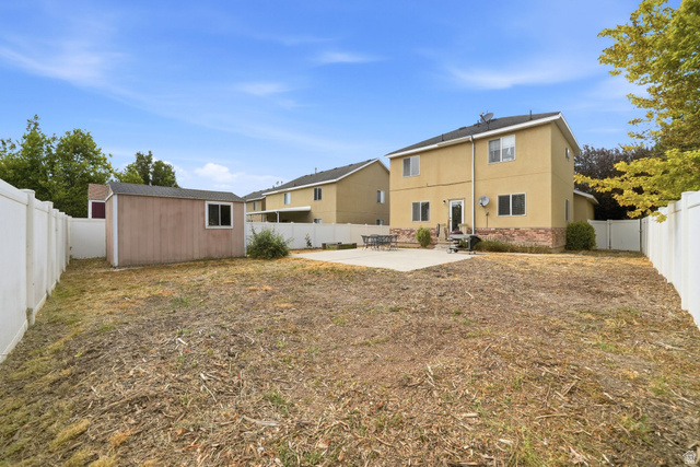 297 West Bricker Road Draper, UT 84020 - Photo 32 of 44 Spacious backyard featuring a storage shed, concrete patio, and full perimeter fencing