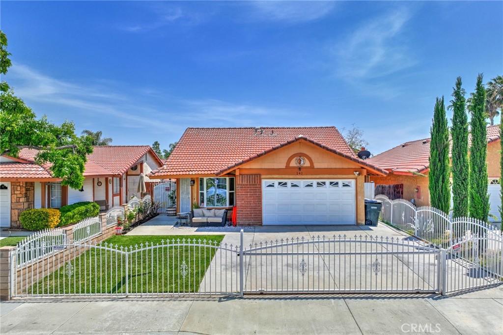 141 Oaktree Drive Perris, CA 92571 - Photo 1 of 1 a front view of a house with a garden
