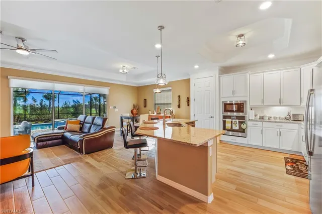 a living room with furniture kitchen and a wooden floor