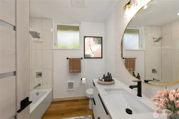 a bathroom with a tub sink and mirror