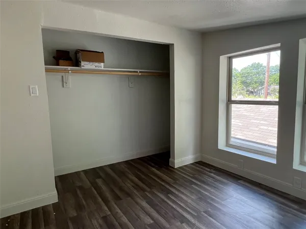 a view of a room with wooden floor and a window