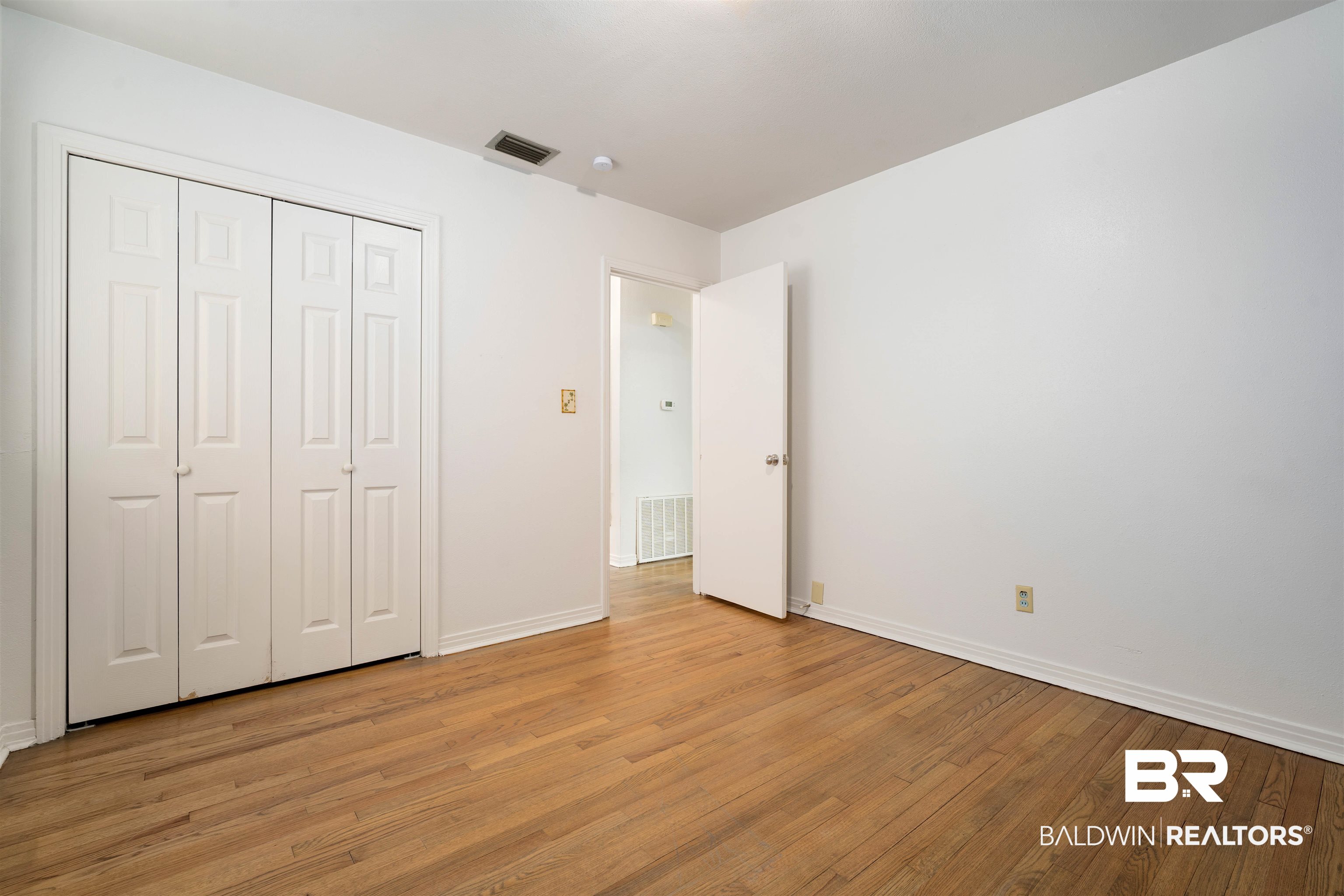 570 Markham Drive Mobile, AL 36609 - Photo 18 of 25 Unfurnished bedroom featuring baseboards, visible vents, and light wood-style flooring