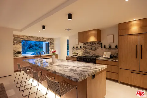 a kitchen with stainless steel appliances granite countertop a stove refrigerator sink and microwave