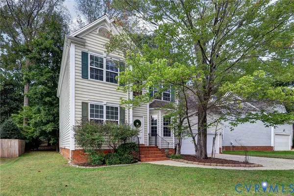 a view of a house with backyard and a tree