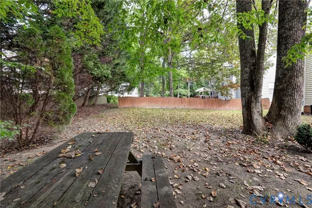 a view of a yard with plants and trees