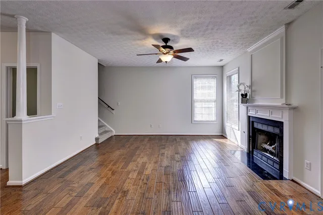 a view of empty room with wooden floor and fireplace
