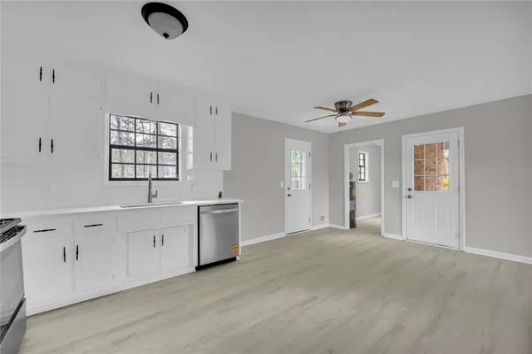 a view of an empty room with window and cabinet