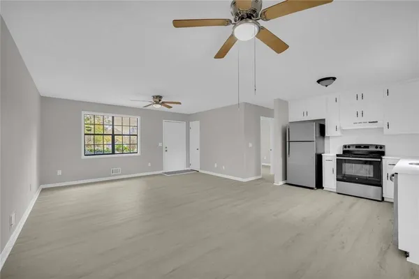 an empty room with windows and ceiling fan