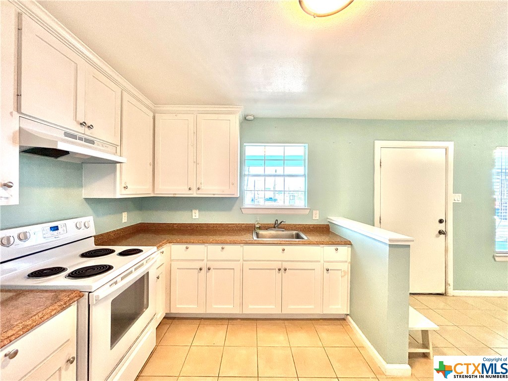 512 West Adams Street Port O'Connor, TX 77982 - Photo 5 of 27 a kitchen with a stove a sink and a refrigerator